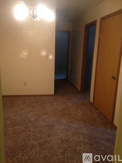 A room with a carpeted floor and a door.