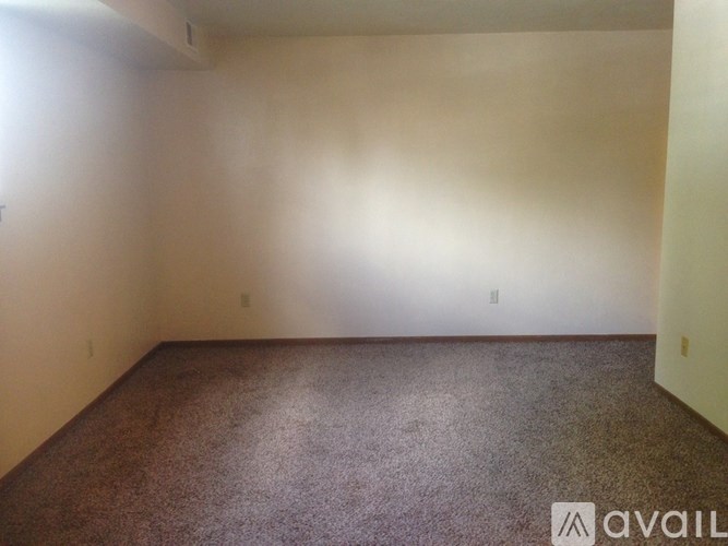 A room with a carpeted floor and white walls.