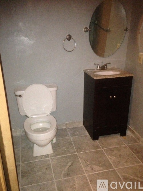 A white toilet sits next to a sink in a small bathroom.