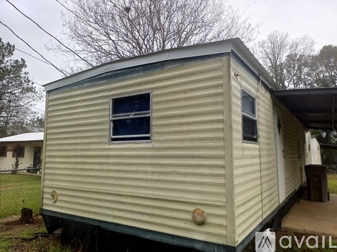 A beige mobile home with a window and a door.
