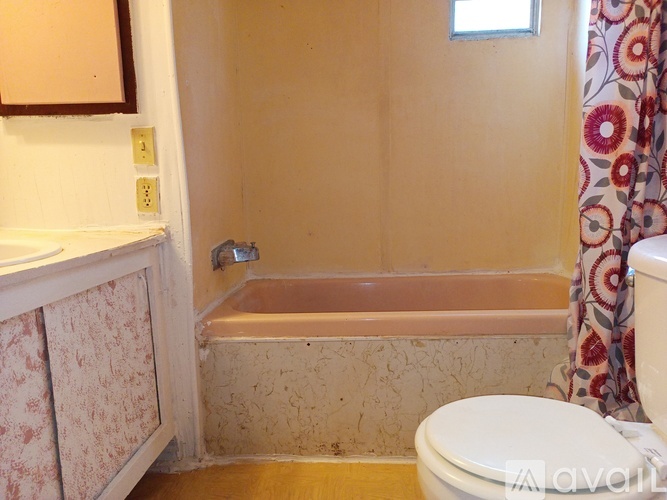 A bathroom with a toilet, tub, and sink.