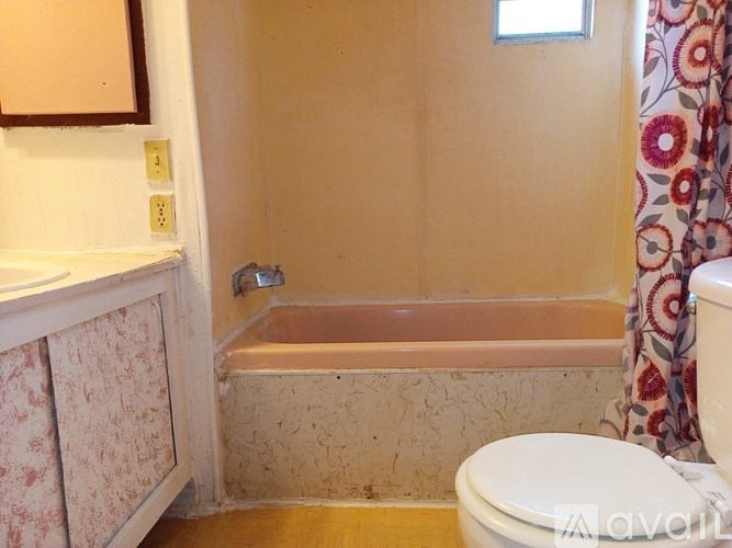 A bathroom with a toilet, tub, and sink.