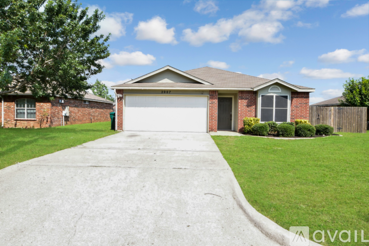 A house with a white garage door and a brown roof.