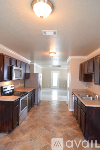 A kitchen with brown cabinets and a tile floor.