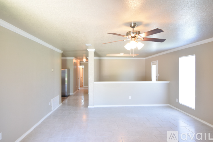 A spacious room with a ceiling fan and light fixture.