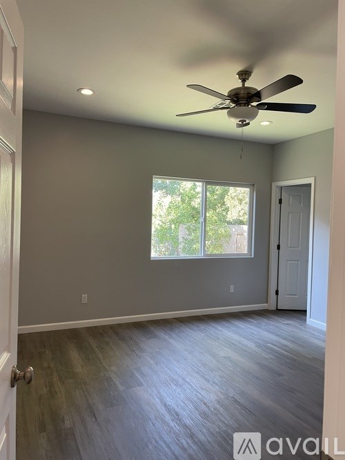 A room with a ceiling fan and a window.