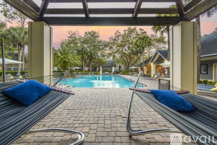 A pool area with a bench and a pool in the middle.
