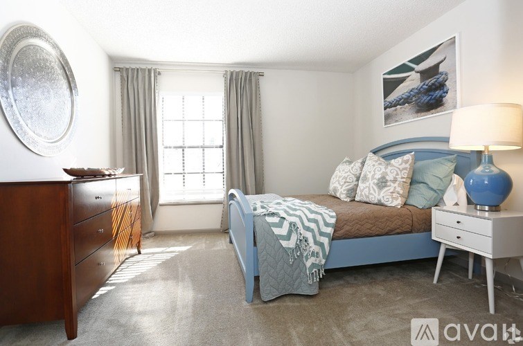 A bedroom with a bed, nightstand, and a dresser.