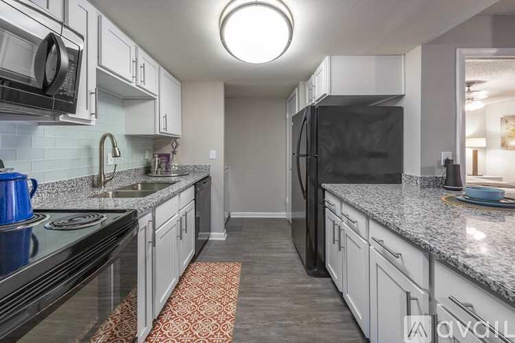 A kitchen with black appliances and white cabinets.