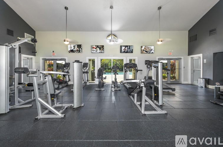 A gym with a variety of equipment including treadmills, weights, and exercise machines.