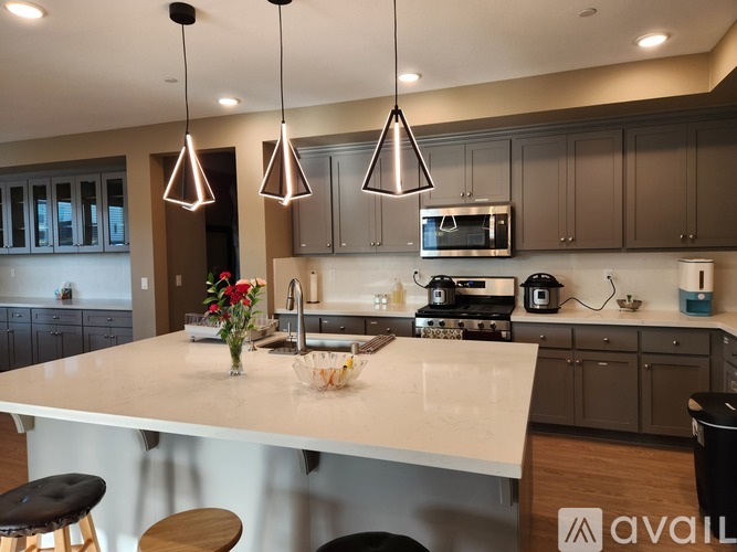 A modern kitchen with a large island and pendant lights.