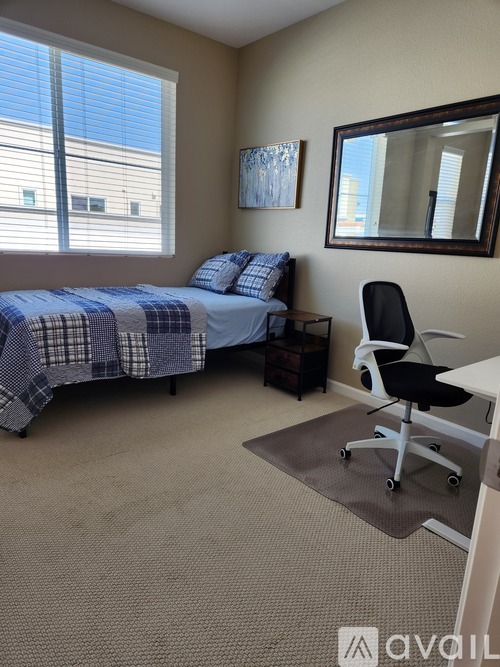 A bedroom with a bed, chair, and window.