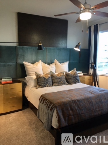 A bedroom with a bed, nightstand, and ceiling fan.
