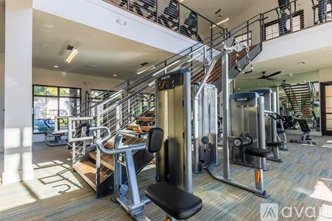 A gym with a variety of equipment including treadmills, weights, and exercise machines.