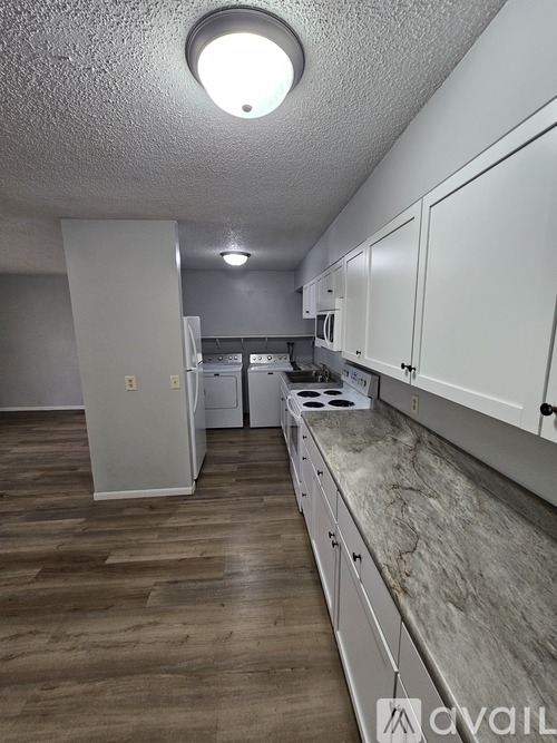A kitchen with a stove, sink, and refrigerator.