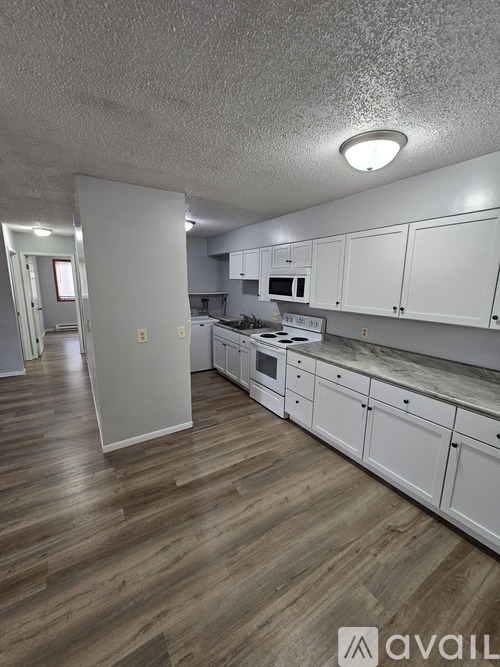 A kitchen area with a stove top oven and a refrigerator.