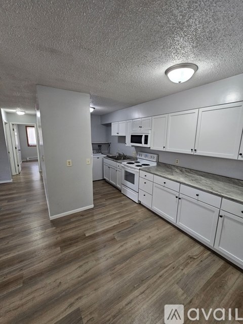 A kitchen area with a stove top oven and a refrigerator.