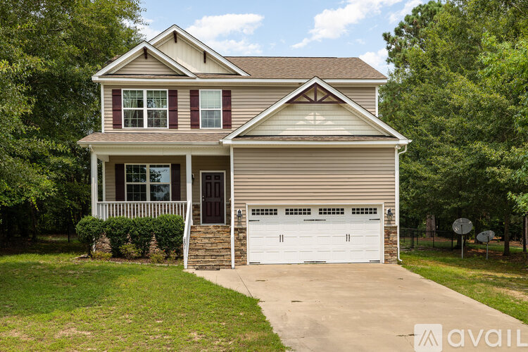 A two-story house with a garage and a driveway.