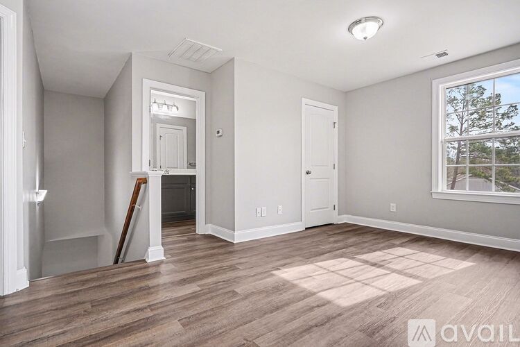 A spacious living room with a fireplace and a ceiling fan.