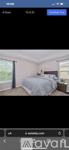 A bedroom with a bed, nightstand, and window.