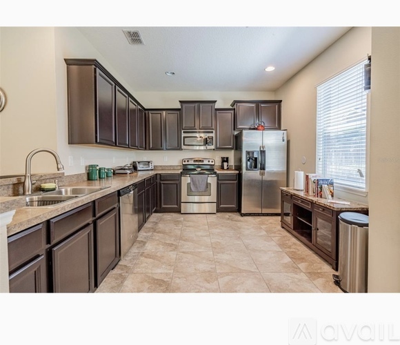 A kitchen with brown cabinets and a tiled floor.