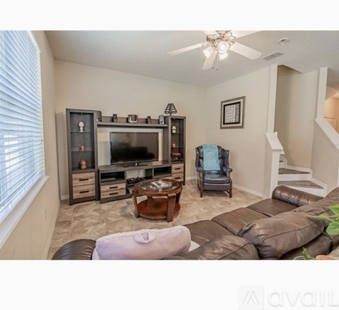 A living room with a brown leather couch and a wooden coffee table.