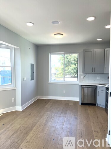 A kitchen with a wooden floor and white walls.