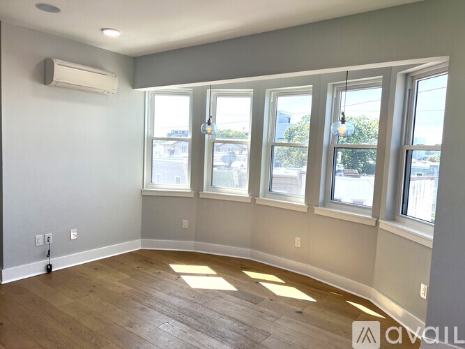 A room with a large window and wooden flooring.