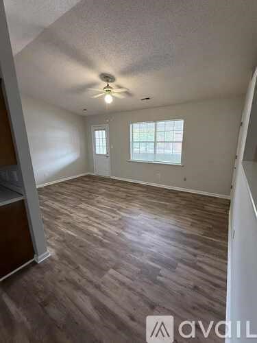 A room with a ceiling fan and wooden flooring.