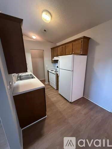 A kitchen with a white fridge and a white sink.