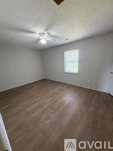 A room with wooden flooring and a window.
