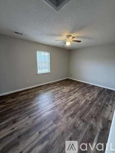 A room with a white door and a brown floor.