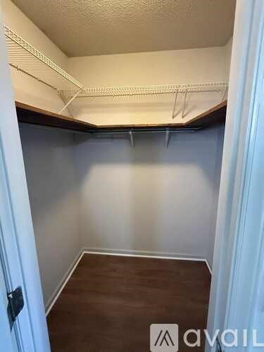 A room with a white door and a brown floor.