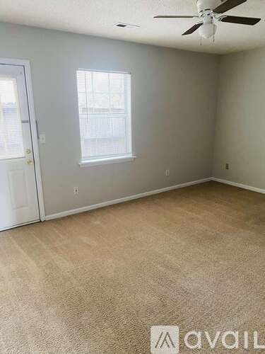 A room with a white door and a brown floor.