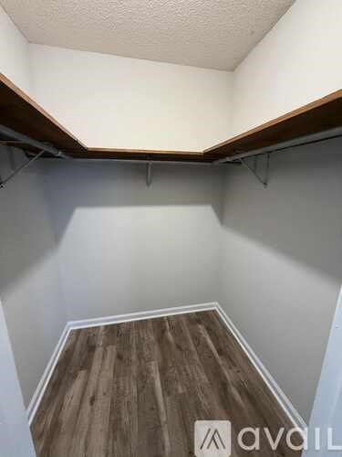 A room with wooden flooring and a brick wall.