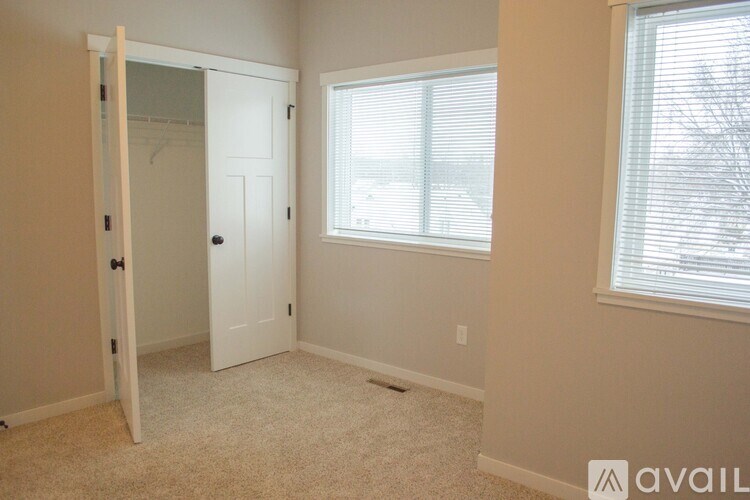 A room with a white door and a window with blinds.