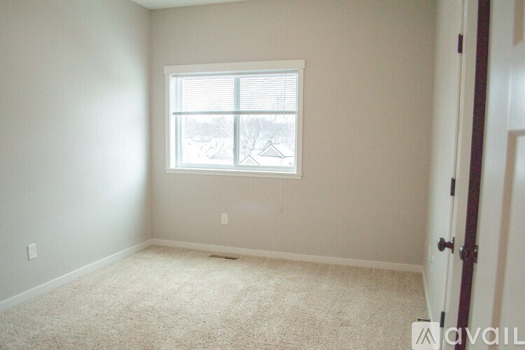 A room with a window and carpeted floor.