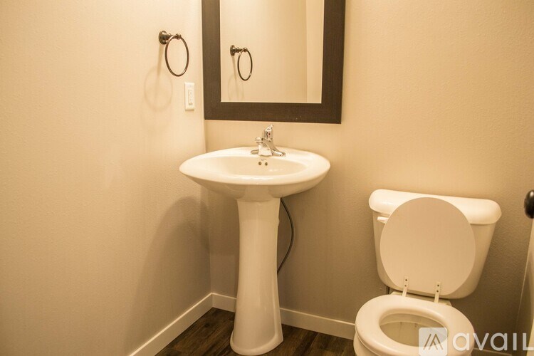 A white toilet sits next to a white pedestal sink in a bathroom.