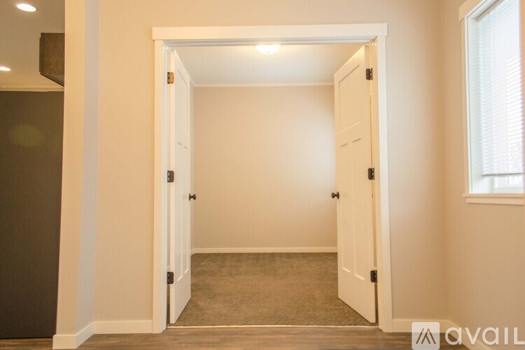 A room with a carpeted floor and a doorway leading to another room.