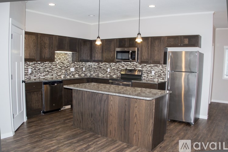 A kitchen with wooden cabinets and a stone backsplash.