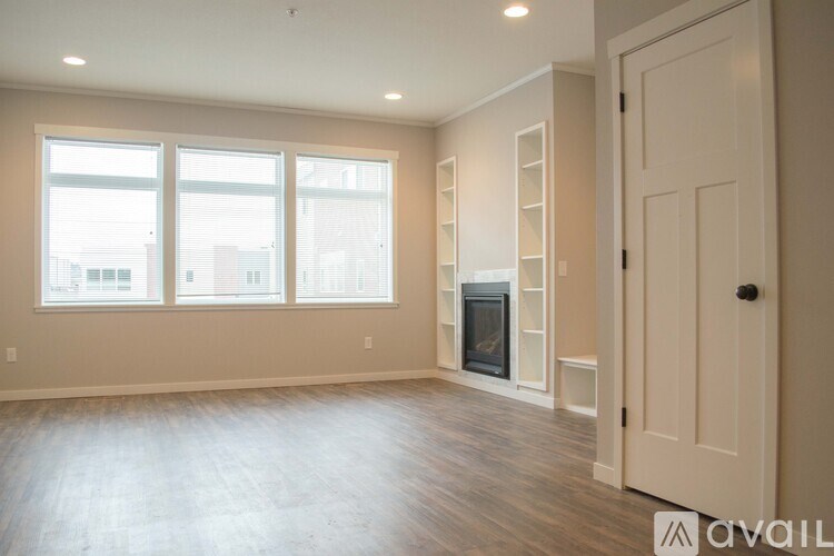 A spacious room with a fireplace and a door on the right side.