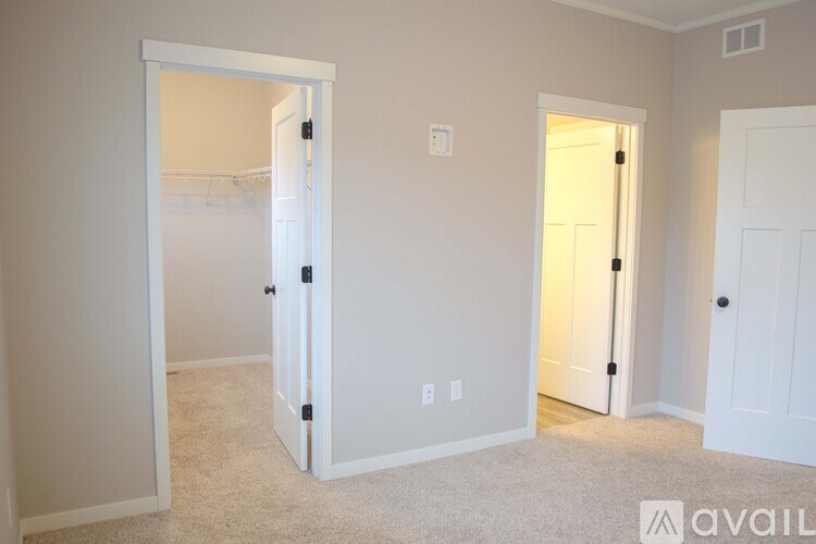 A room with two doors, one open, and a carpeted floor.