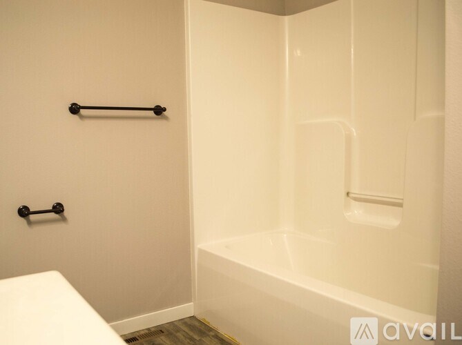 A white bathroom with a white tub and a white toilet.