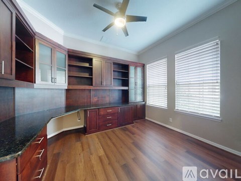 A kitchen with wooden floors and white cabinets.
