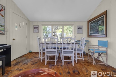 A dining room with a white table and chairs.