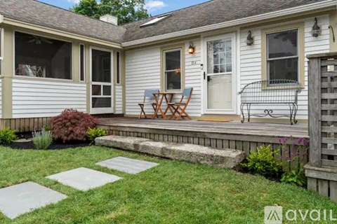 A small house with a porch and a lawn.