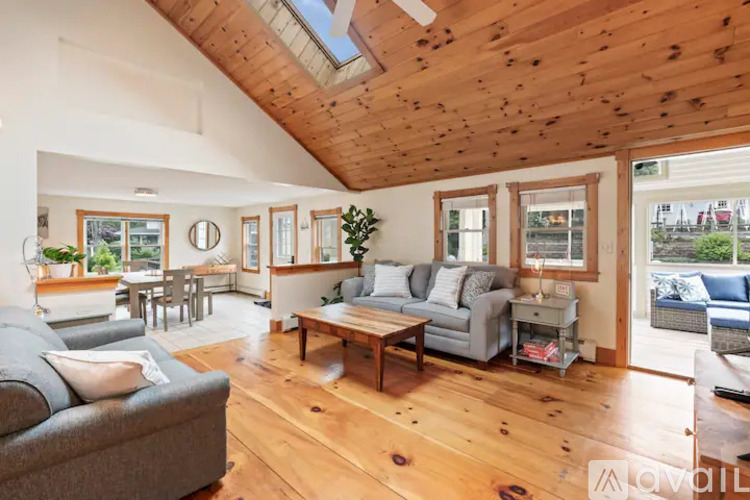 A living room with wooden floors and a skylight.