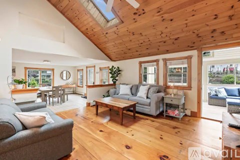 A living room with wooden floors and a skylight.