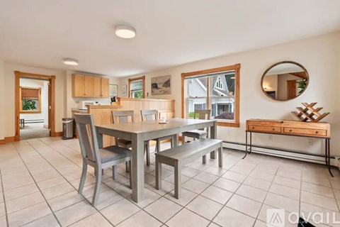 A dining room with a table and chairs.