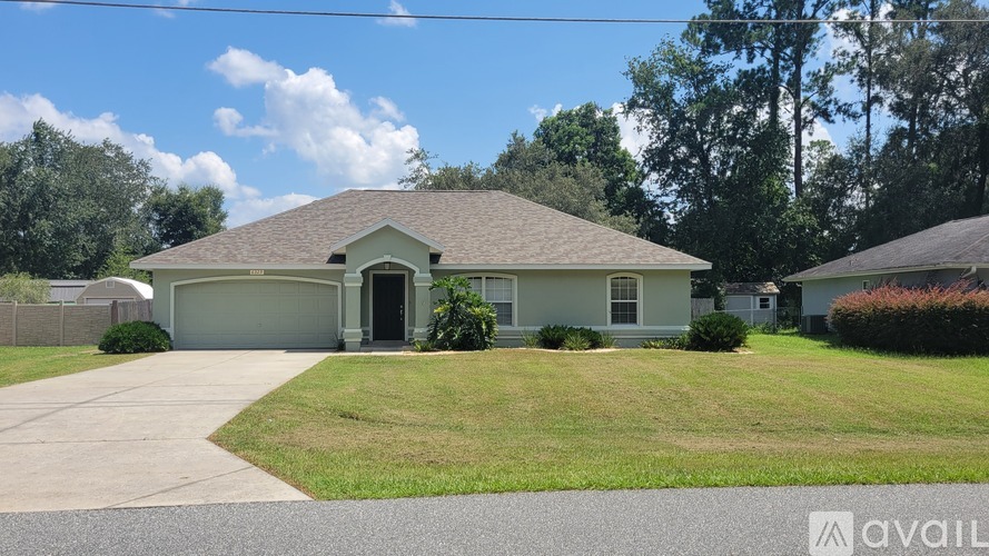A house with a grey roof and a driveway in front of it.